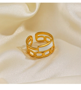 Detail of adjustable gold chain ring featuring a white enamel inlay on silk fabric
