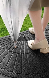 Close-up of semi-circular gray door mat showing rapid water absorption and anti-slip texture