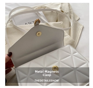 Detailed macro view showing the secure gold magnetic snap closure on a white quilted bag
