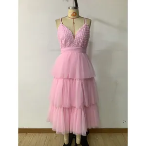 Détail d'une jupe en tulle rose à volants avec fleurs 3D et corsage délicat à col en V