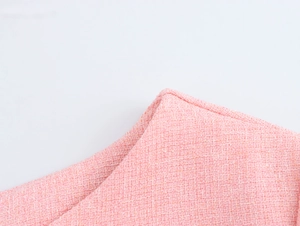 Close-up of pink tweed fabric texture showing intricate woven fibers and soft knit finish