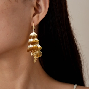 Detail of layered gold leaf earrings with small diamond accent on a model's ear