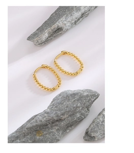Macro detail of gold plated S925 sterling silver hoop earrings with bead design