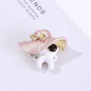Creative tooth shaped brooch with pink striped hat and sunglasses on a stylish background