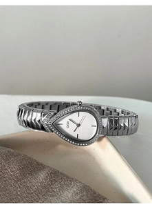Macro view of silver water-drop watch face with sparkling rhinestones and metal strap