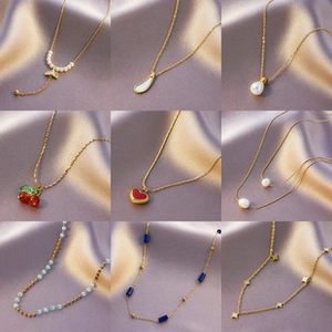 Collage of chic gold-plated necklaces with pearl and heart pendants on purple velvet