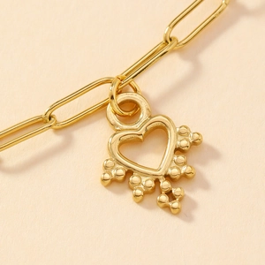 Golden stainless steel bracelet with a hollow heart pendant and small decorative beads