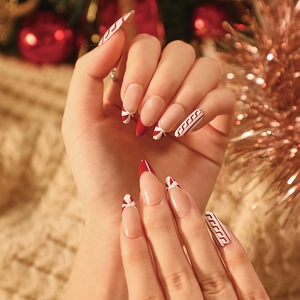 Christmas almond press-on nails with red and white candy cane patterns for women