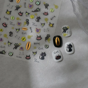 Detailed view of DIY black cat nail decals with fishbone patterns and glitter finish