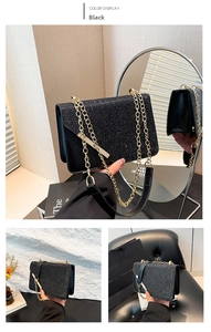 Detail of black sequined crossbody bag with a chunky gold chain strap and metal trim