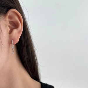 Close-up of S925 silver drop earring with zircon heart pendant on model ear