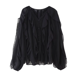 Detail view of the black chiffon blouse featuring ruffled sleeves and button closure