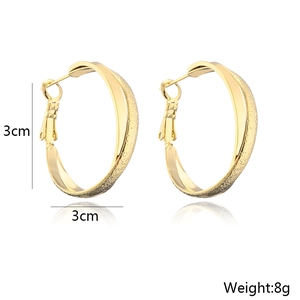 Detail view of 3cm gold-plated geometric hoop earrings showing 8g weight and matte texture