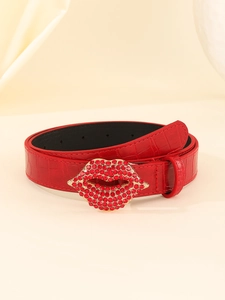 Macro detail of red crocodile texture belt with a luxury rhinestone studded lip buckle