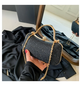 Detail of elegant black sequin evening bag with gold metal handle and diamond clasp