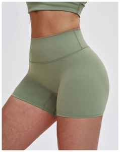Dettaglio degli shorts da yoga verde salvia a vita alta con compressione e cuciture