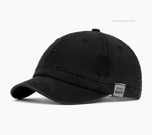 Detail of black short brim baseball cap showing side woven label and cotton twill texture