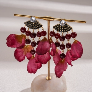 Detailed shot of retro fan-shaped tassel earrings with red silk petals and dark beads