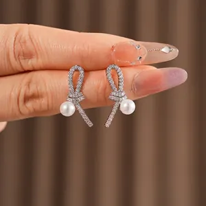 Boucles d'oreilles nœud en argent serties de zircons avec perles blanches élégantes