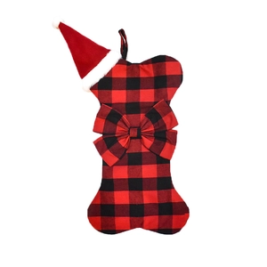 Close-up of bone-shaped red and black plaid Christmas stocking with bow and santa hat decoration