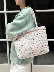 Quilted cotton tote bag with cute cartoon animal print on a female shoulder