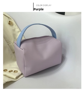 Detail of purple PU leather mini handbag featuring light blue textured handles and top zipper