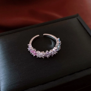 Dettaglio dell'anello regolabile in argento con zirconi sfumati colorati su una scatola nera
