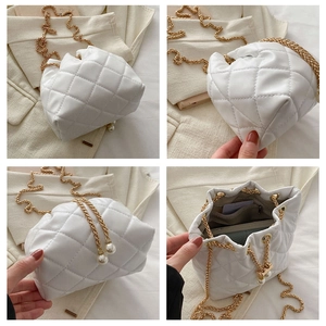 Detail view of quilted bucket bag with pearl drawstring and golden chain strap