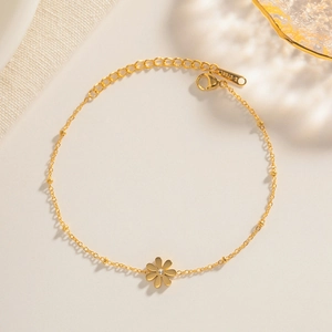 Minimalist gold lily of the valley flower bracelet in durable stainless steel on white background
