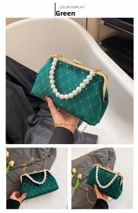 Close-up of emerald velvet shell bag with rhinestone quilt and pearl handle