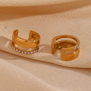 Vue macro de boucles d'oreilles C à double couche dorées avec des zircons brillants