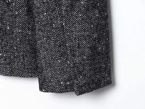 Dettaglio macro del tessuto tweed a spina di pesce bianco e nero con cuciture di pregio