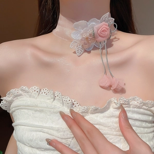 Detail of pink fabric rose choker with lace leaves and delicate ribbon tassels