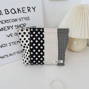 Close-up of black and white polka dot canvas makeup bag in a lifestyle setting