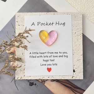 Gradient resin pocket hug heart with encouraging message card on a stone surface