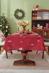 Close-up of red Christmas tablecloth featuring white reindeer and snowflake patterns