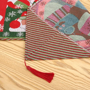 Close-up of knit Christmas table runner with snowflake patterns and red tassel detail