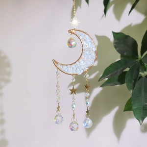 Detail of moon crystal suncatcher with gold wire, opal stones, and faceted prism balls