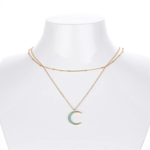 Detail of double-layer gold necklace featuring a blue turquoise crescent moon pendant