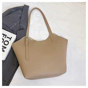 Dettaglio della grande borsa tote kaki con grana litchi e bordo ondulato alla moda