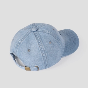 Close-up of washed blue denim baseball cap showing fabric texture and adjustable metal buckle