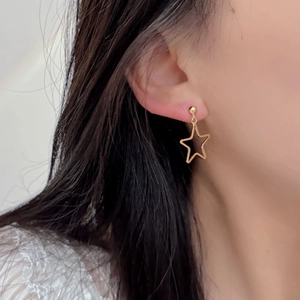 Close-up of minimalist S925 silver hollow star drop earrings worn by a model