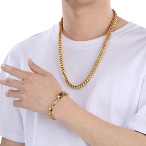 Close-up of a man wearing a golden braided dragon bone chain necklace and bracelet set