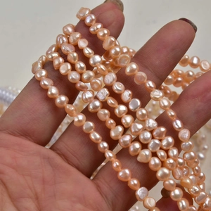 Detailed close-up of 4-5mm baroque freshwater pearls in natural pink orange luster