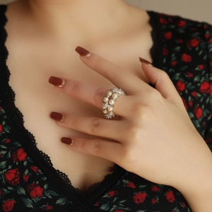 Detail of elegant double-row pearl ring with zircon accents on a model's finger