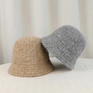 Cozy winter knitted bucket hats in beige and grey featuring thick warm fuzzy texture