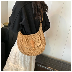 Straw crescent bag with leather buckle pocket and long shoulder strap on a model