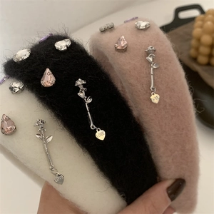 Close-up of plush headbands with sparkling rhinestones and silver rose LOVE pendants