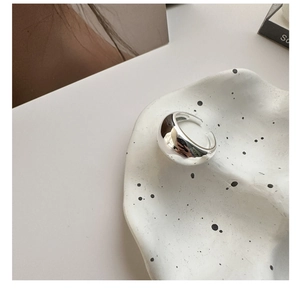 Vista dettagliata di un anello minimalista in argento S925 su un vassoio artistico bianco