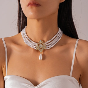 Detail of multi-layer faux pearl necklace with gold diamond pendant in baroque style